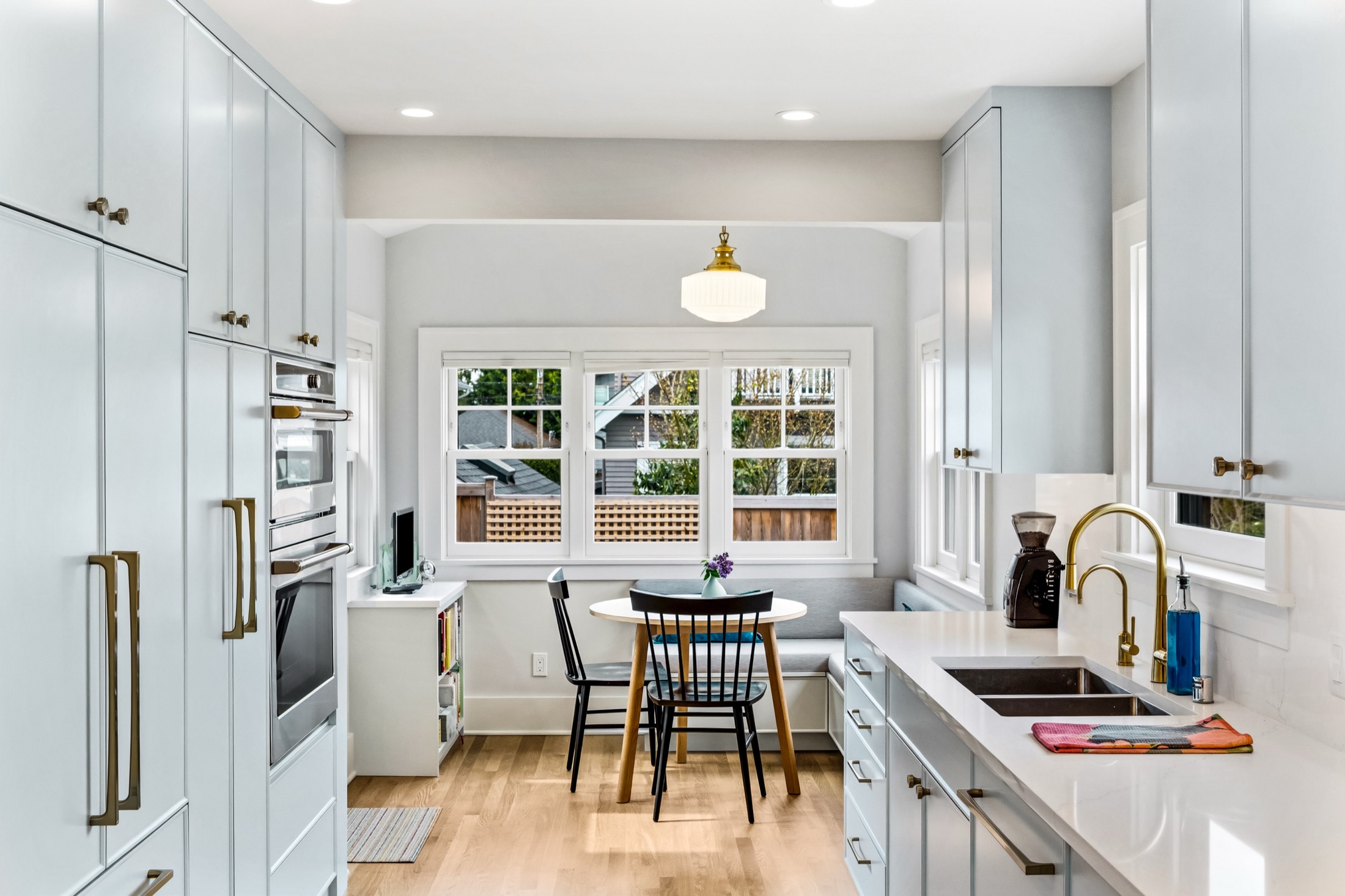 Tangletown kitchen with custom cabinetry, brass fixtures, and a built-in breakfast nook