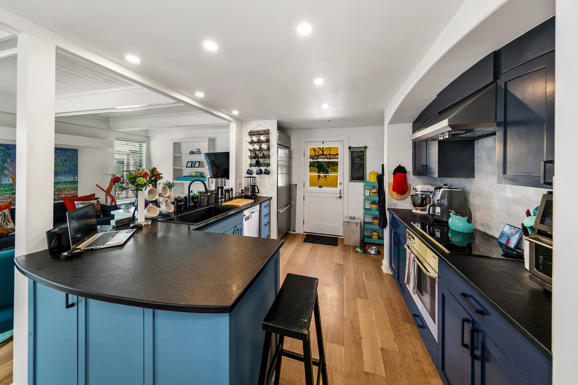Remodeled kitchen with blue cabinetry and curved counter