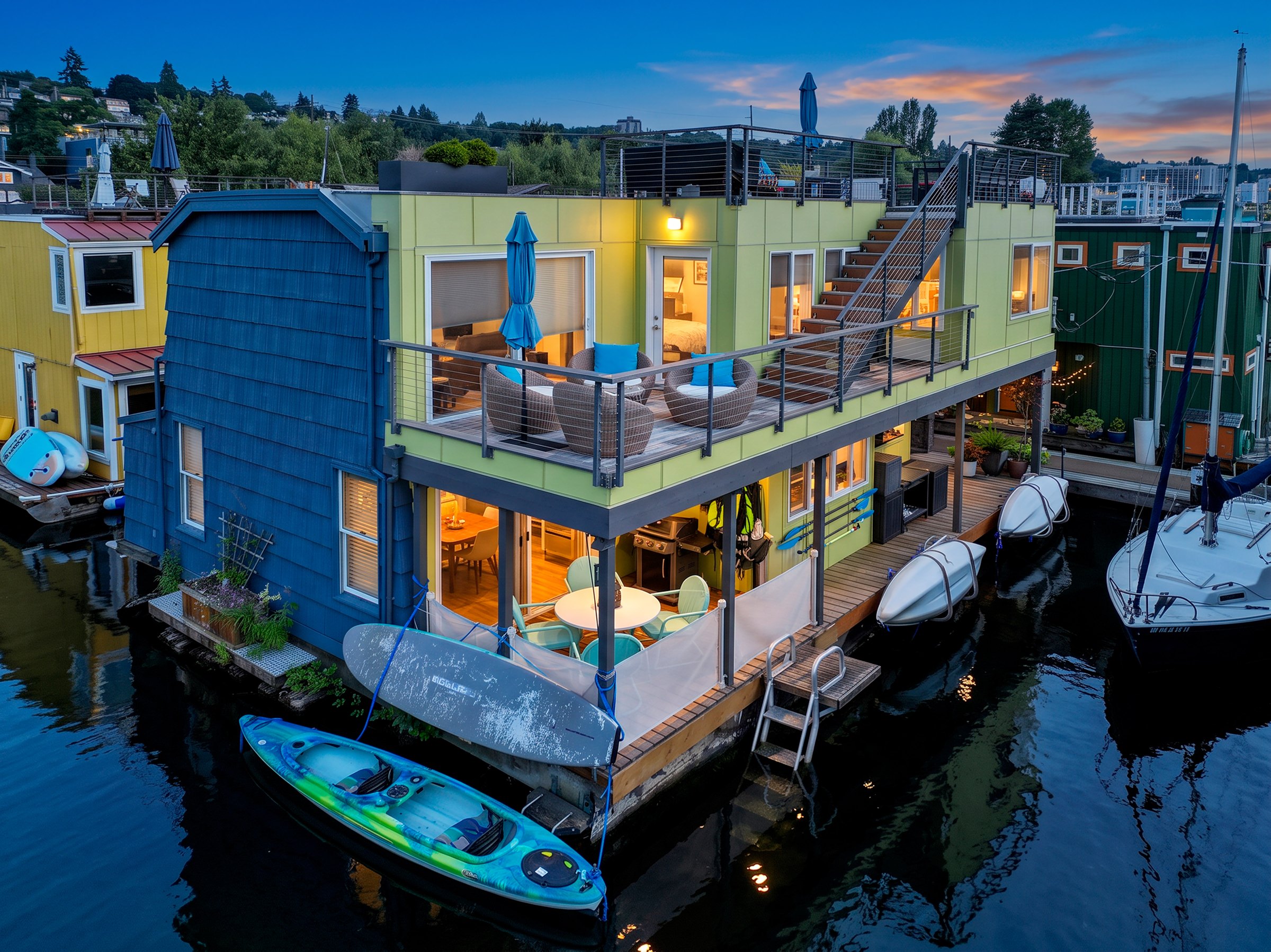 Aerial twilight view of an Eastlake floating home with illuminated decks