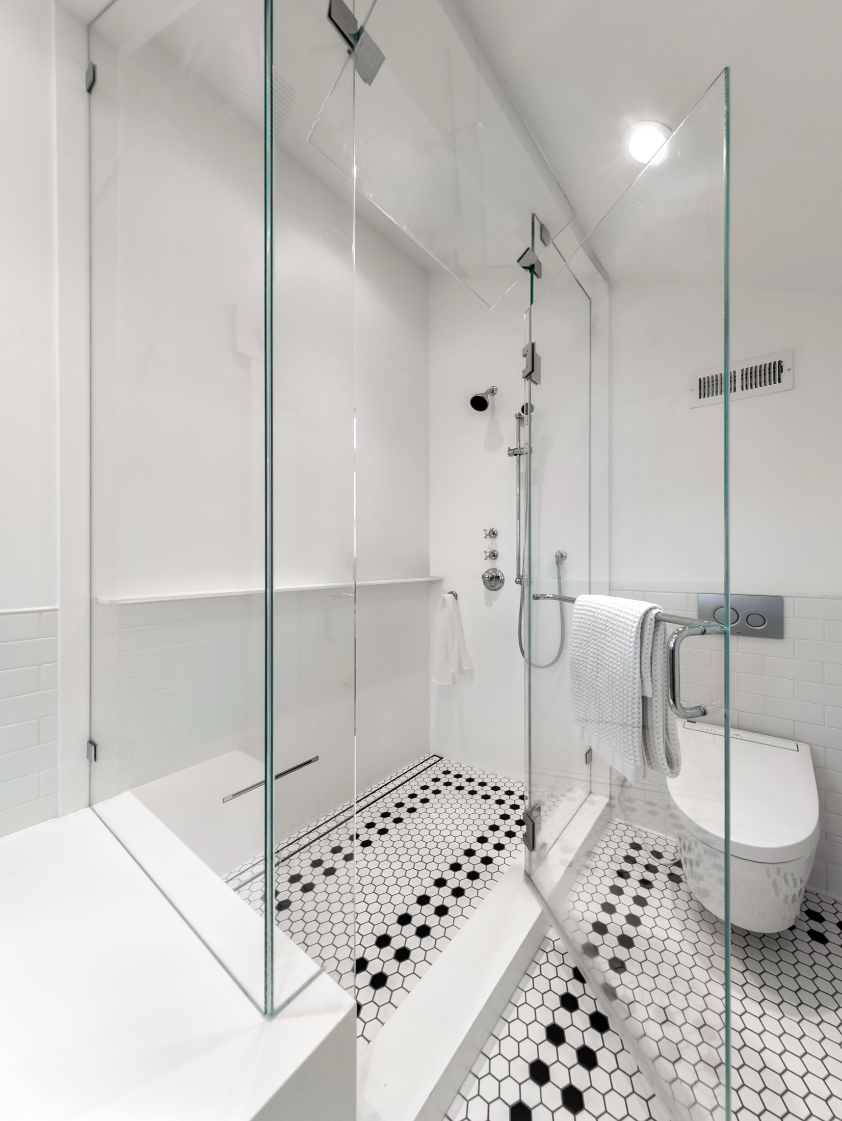 Detailed view of shower fixtures and frameless glass