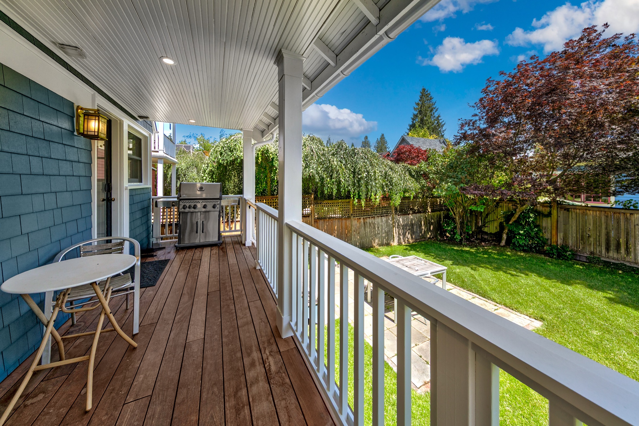 Covered porch overlooking the landscaped backyard