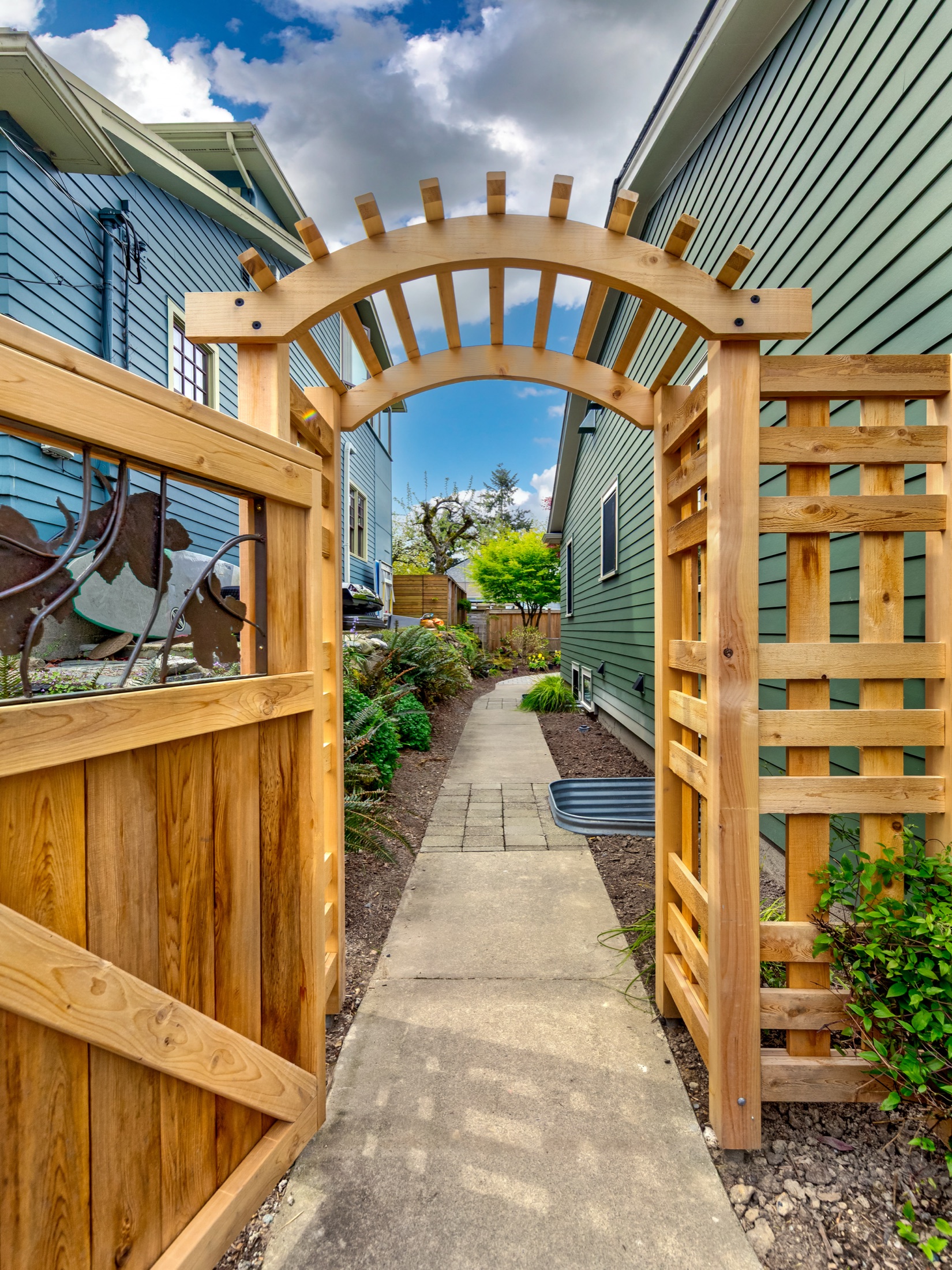 Crafted wood garden trellis beside the remodeled home