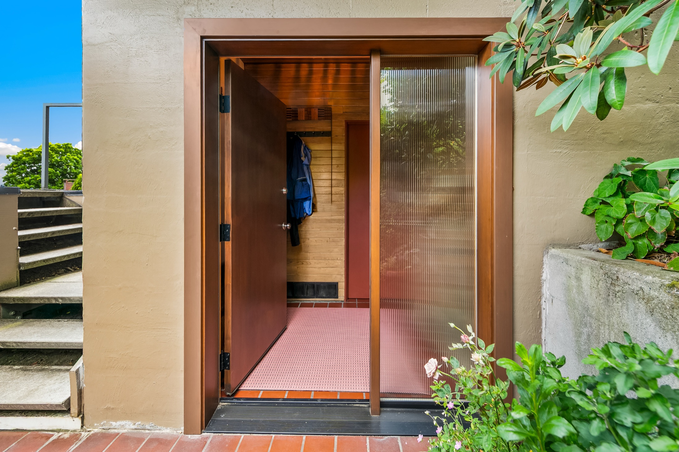 Open front door revealing the warm wood entry ceiling