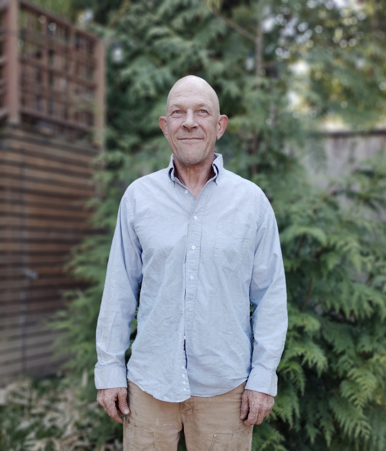 Dave, master carpenter, standing outdoors in a garden